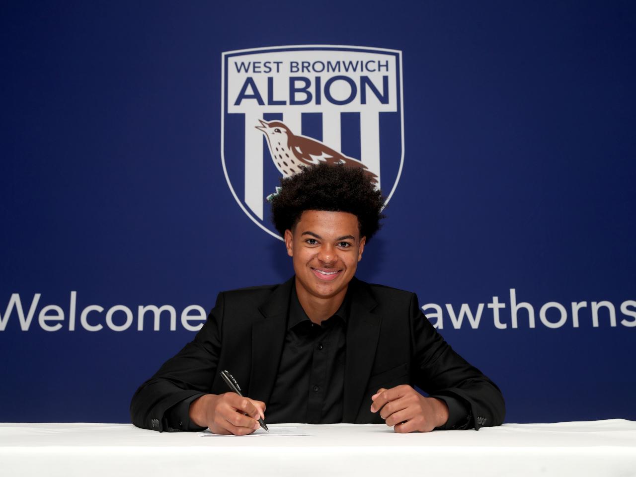 A photo of Albion scholar Maxwell Moses signing scholarship terms ahead of the 2025/26 season