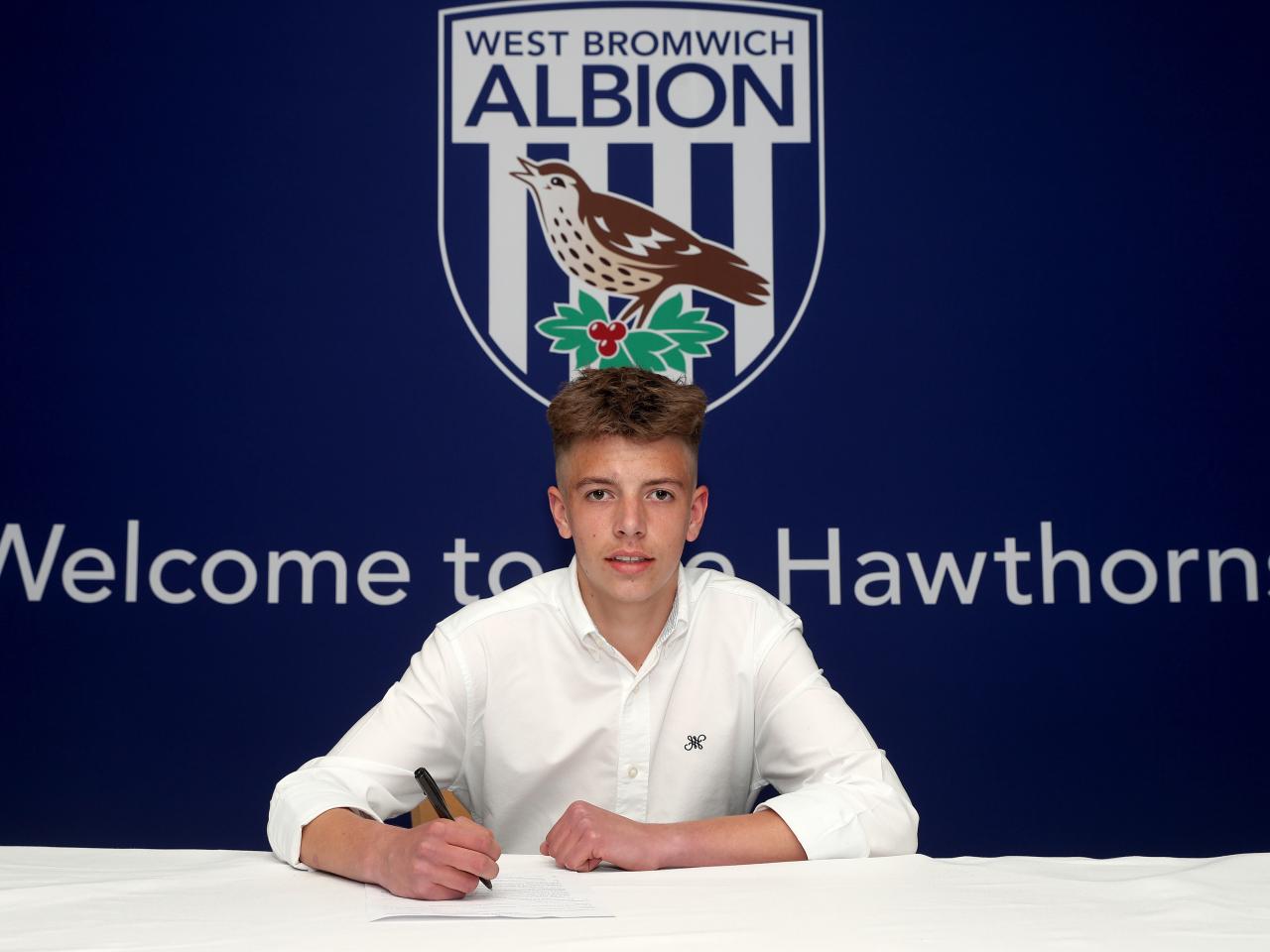 A photo of Albion scholar Reece Bastafield signing scholarship terms ahead of the 2025/26 season