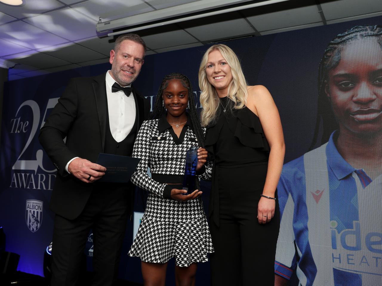 Asiah Janny and Hannah George pose for a photo with a sponsor on stage at the end of season awards 