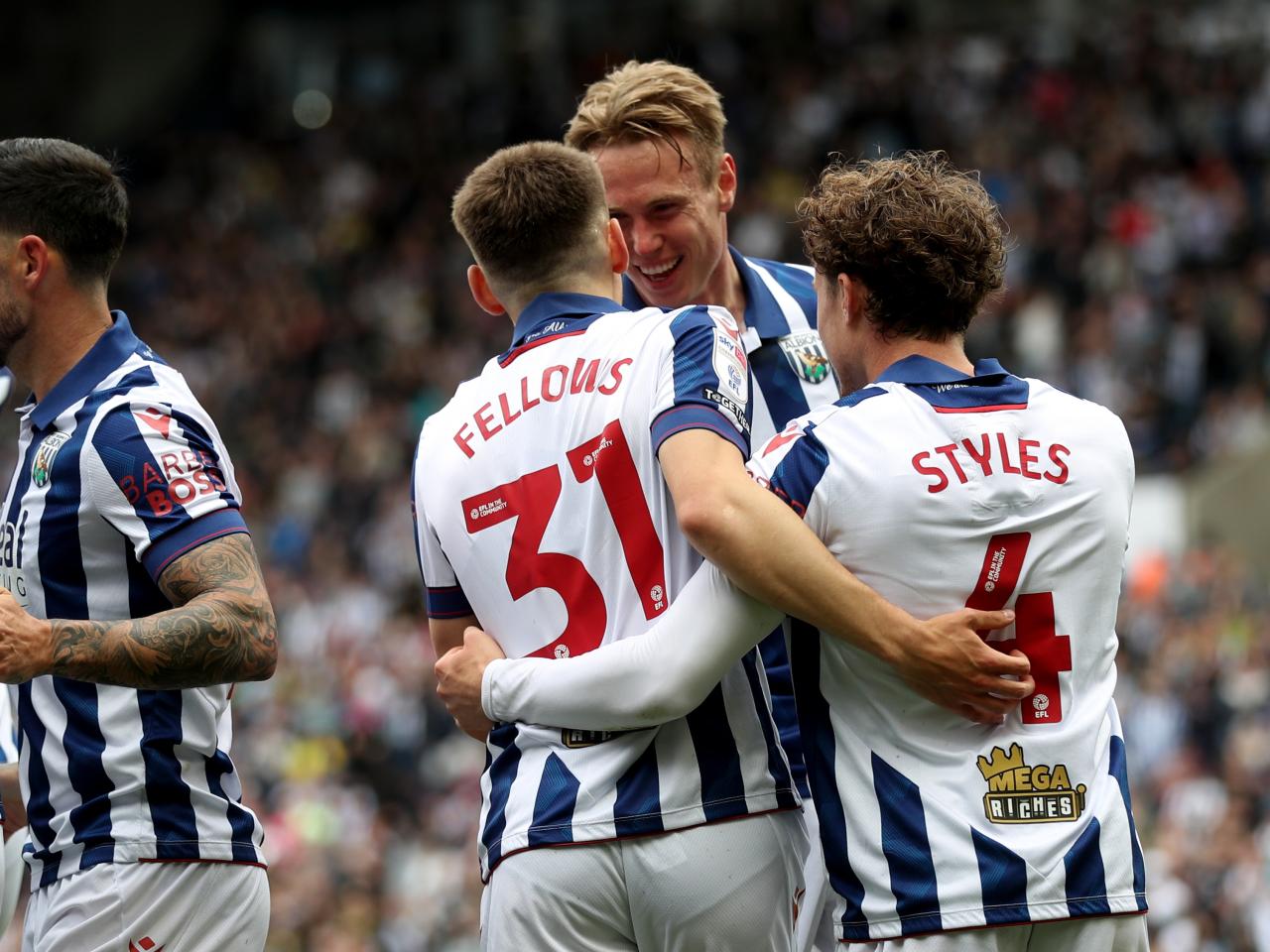 Tom Fellows celebrates with team-mates after scoring against Luton Town