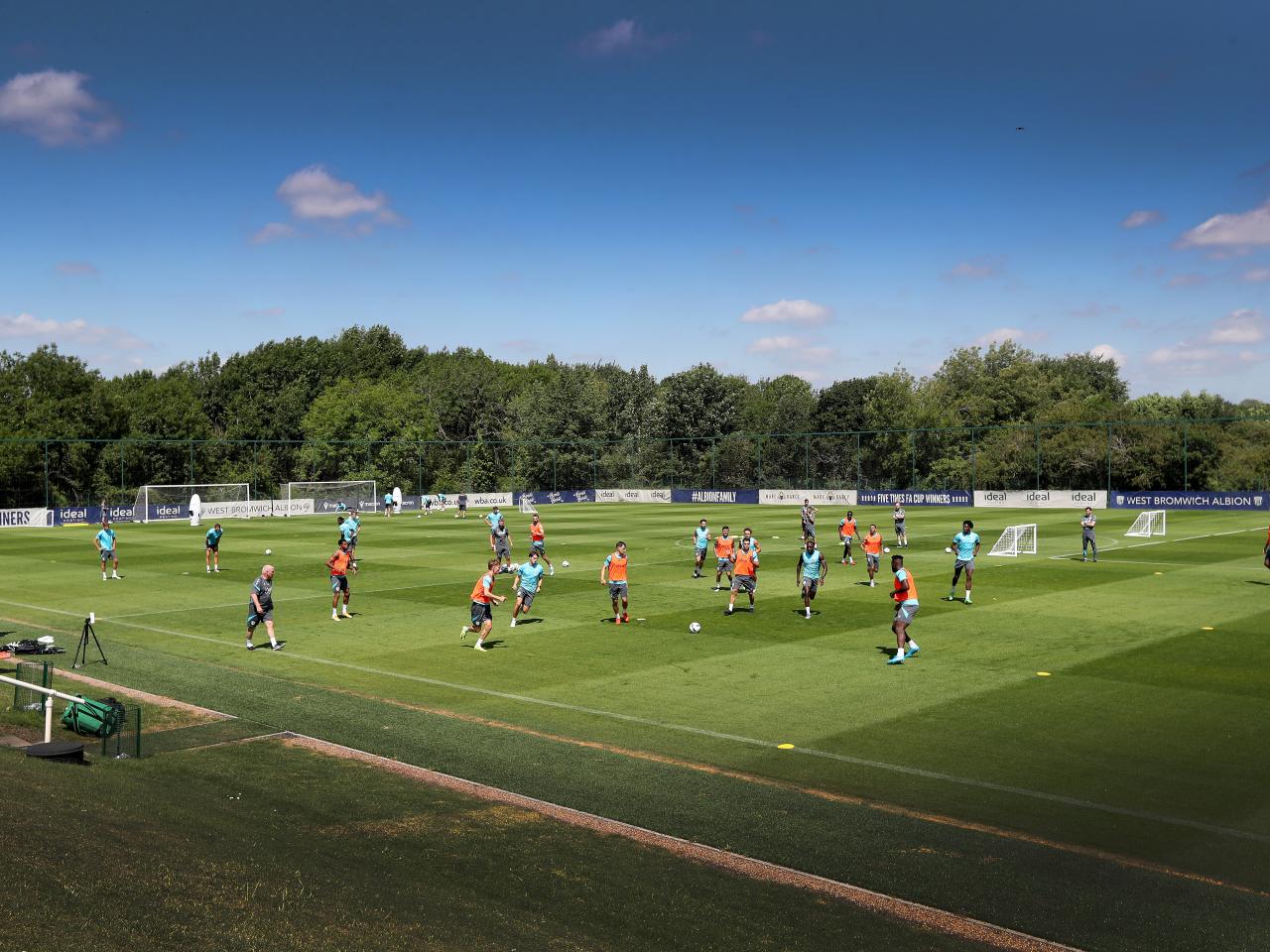 A general wide view of a training session with the majority of the pitch in shot and blue skies above