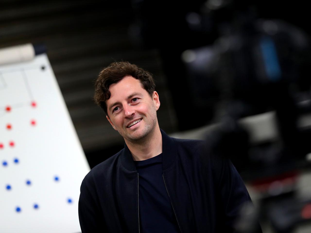 Ryan Mason smiling while sat in front of a tactics board 