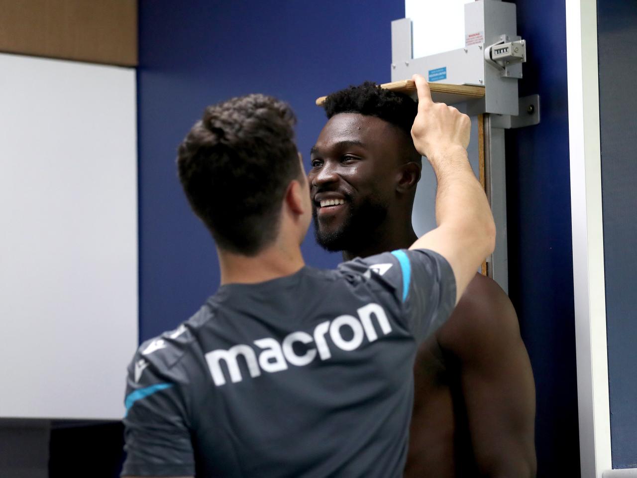 Daryl Dike's height is measured by a member of staff 