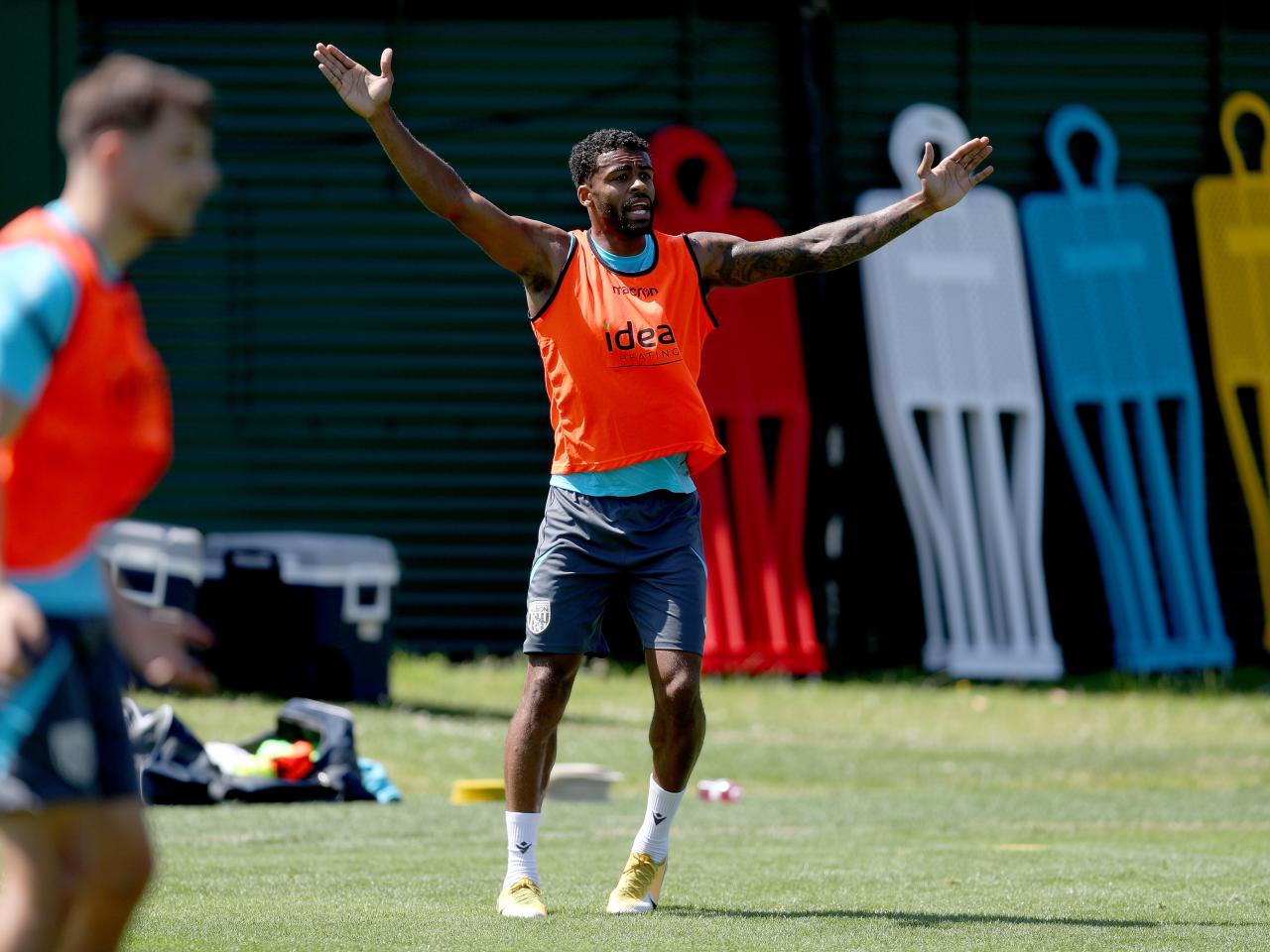 Darnell Furlong with both arms in the air during a training session