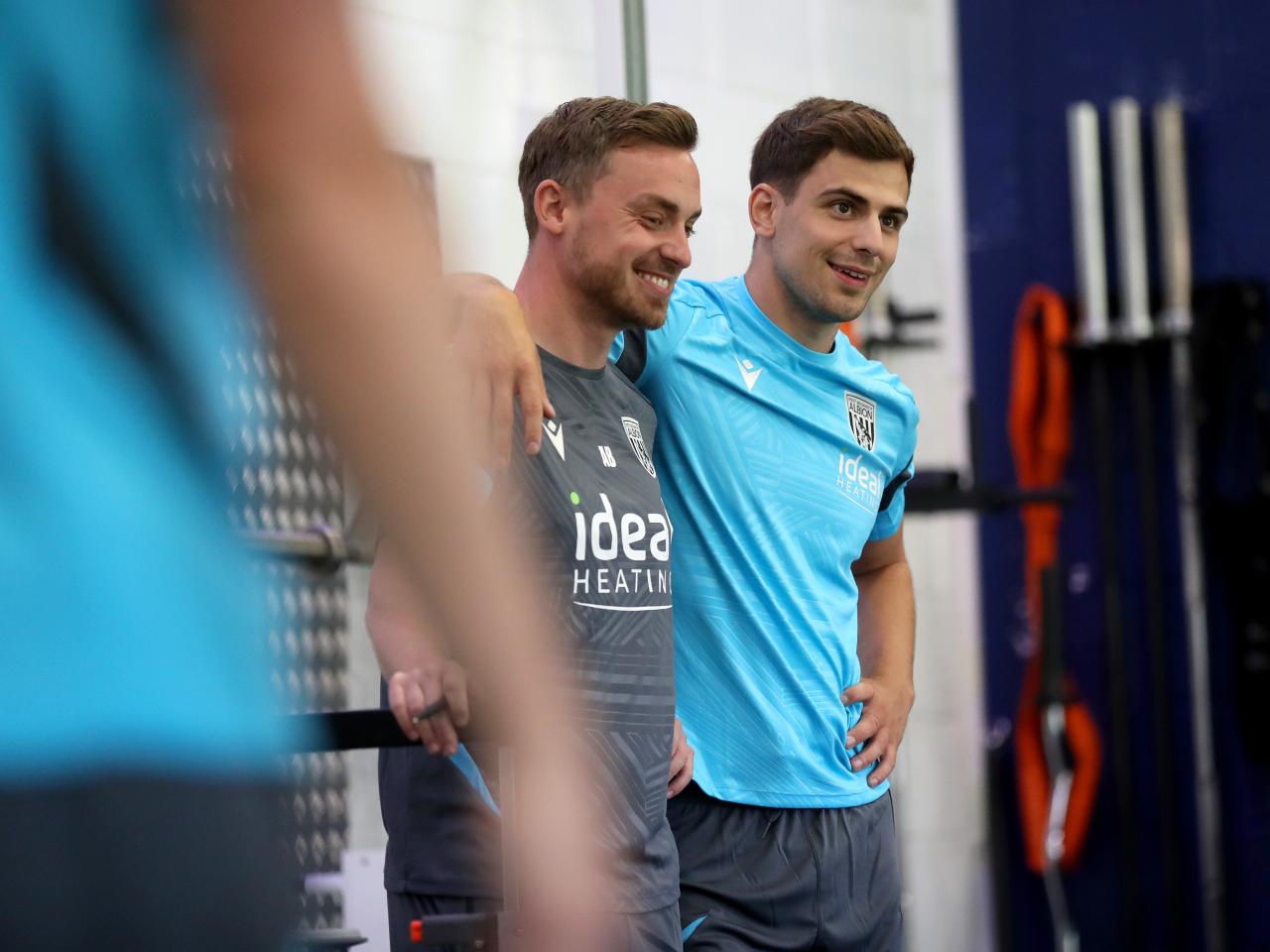 Jayson Molumby with his arm around a member of staff smiling in the gym