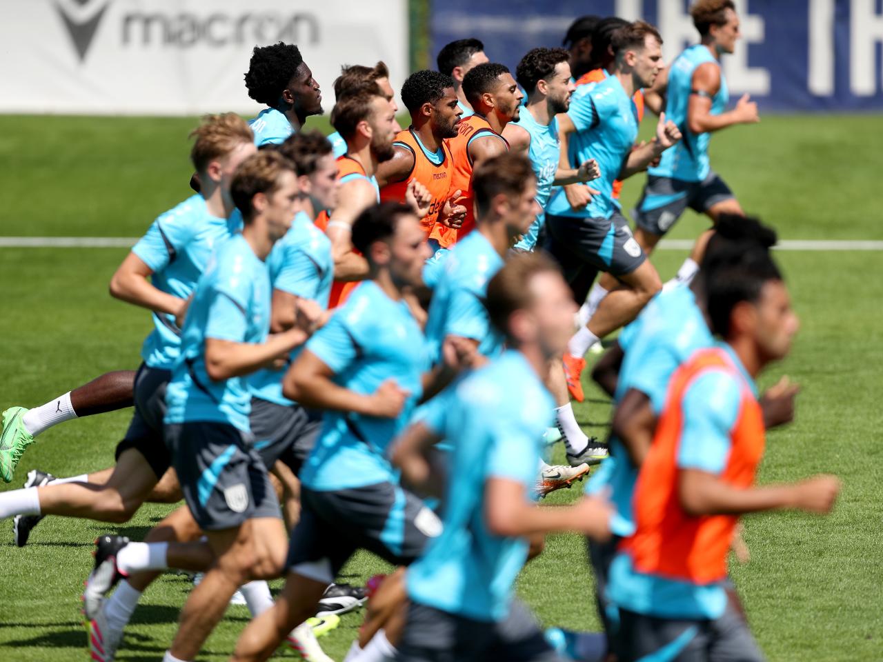the first-team squad in a line running forward during a training session
