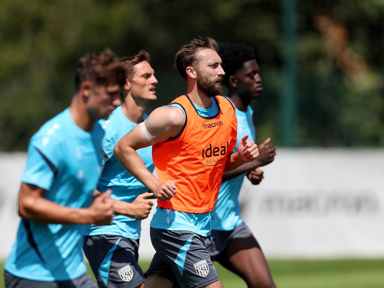 Nat Phillips and three team-mates running forward during a training session