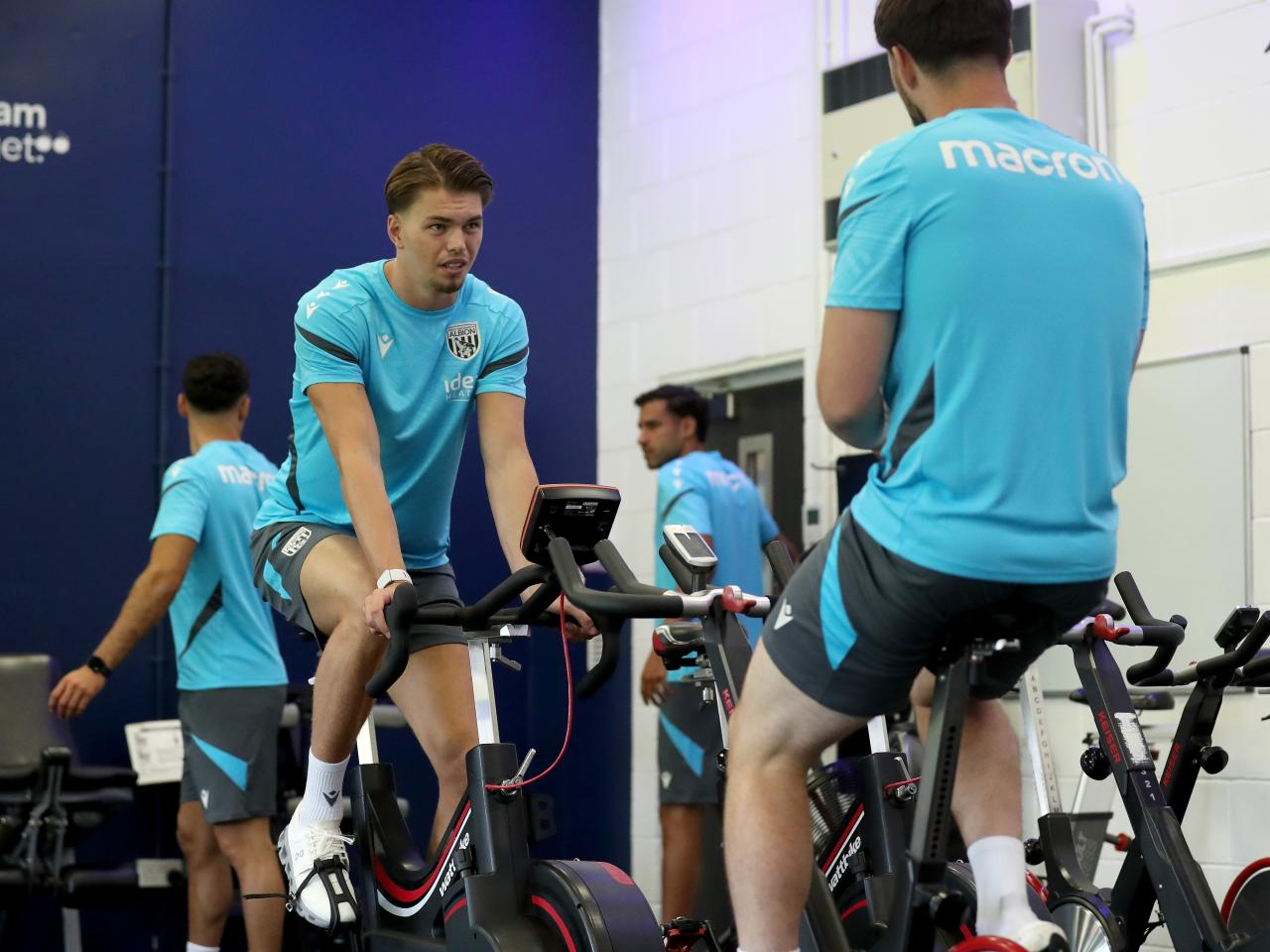 Josh Griffiths and Joe Wildsmith sat on exercise bikes chatting in the gym