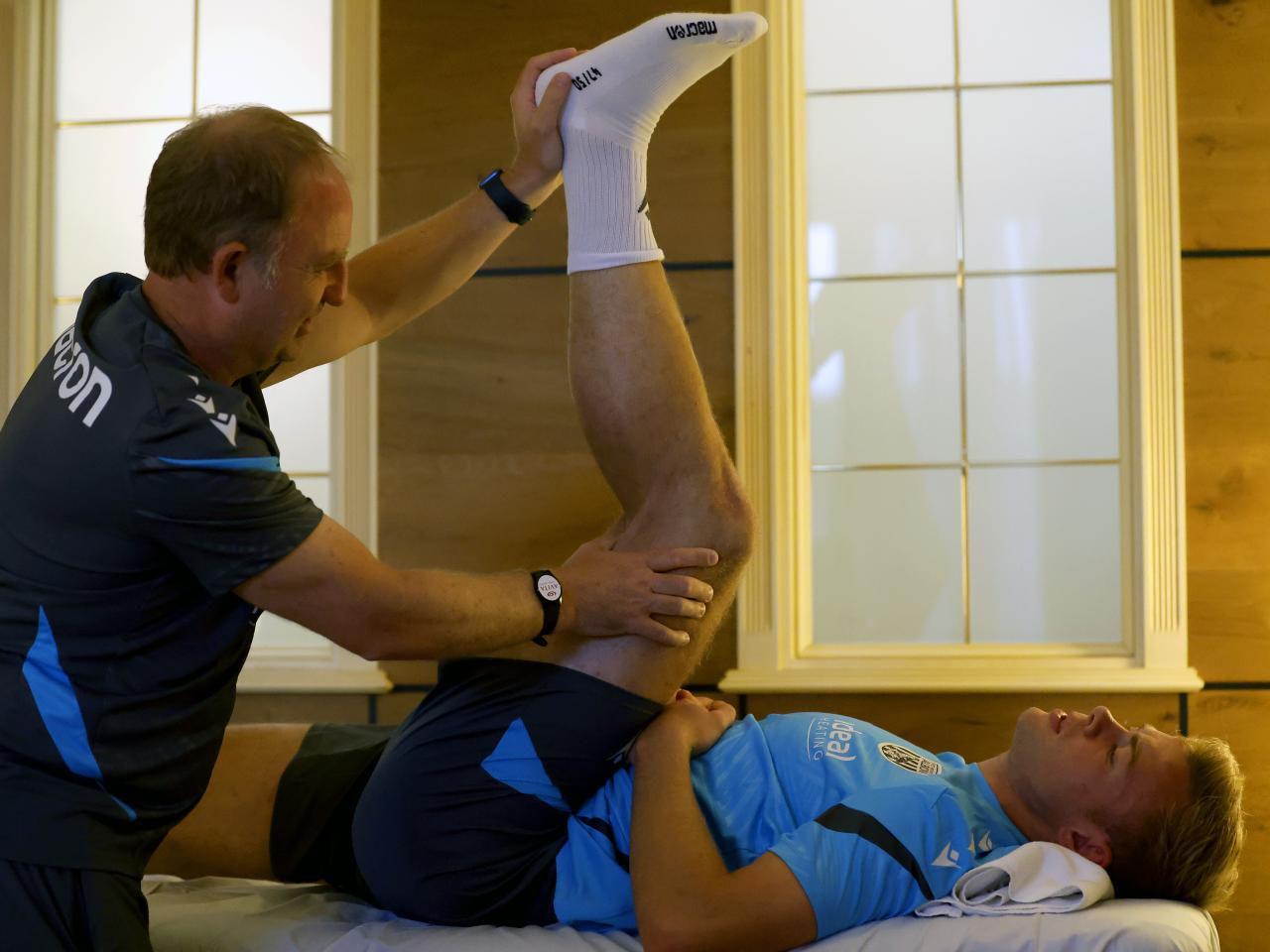 Aune Heggebø stretching with a member of staff on a medical bed