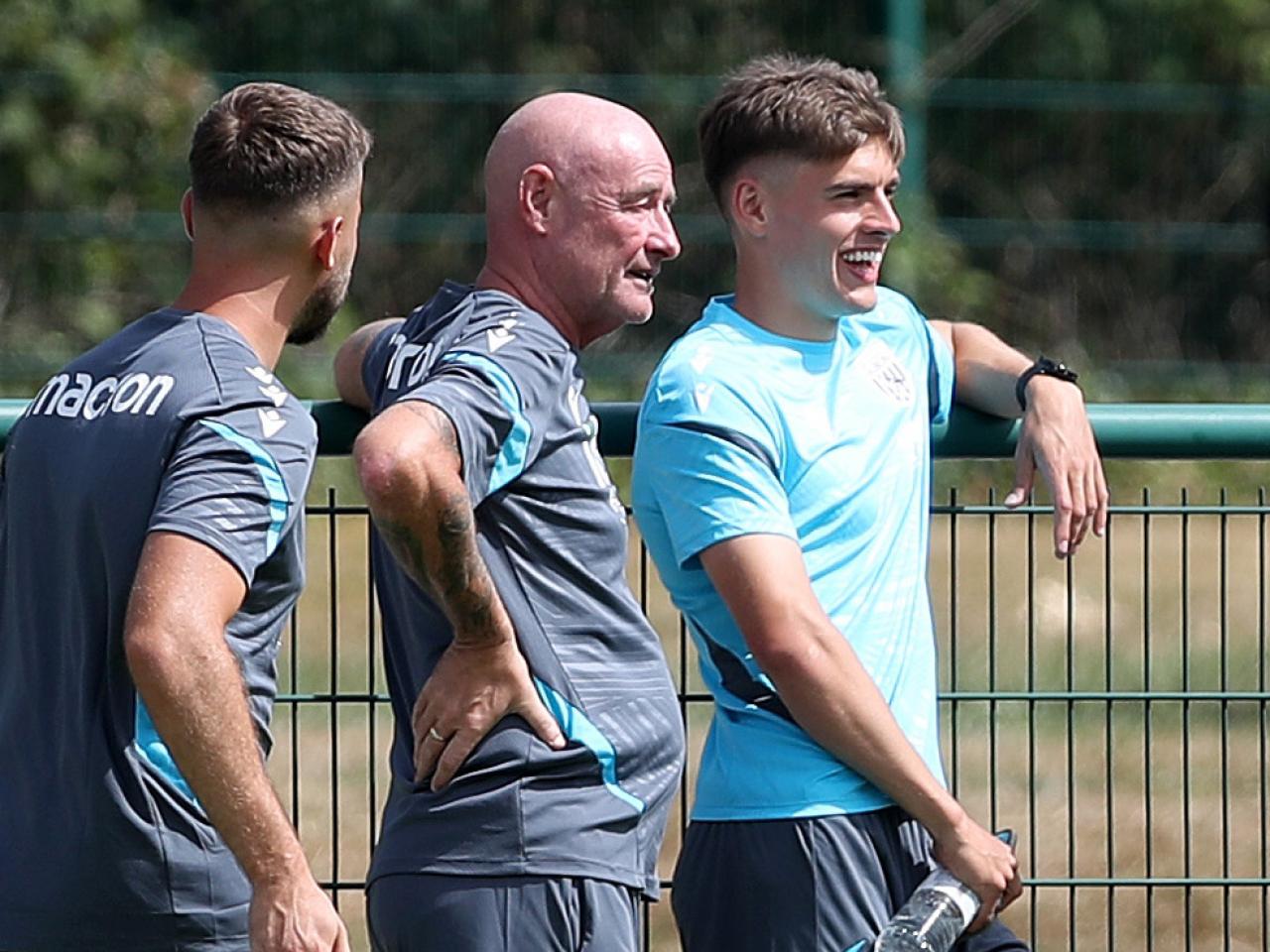 Tom Fellows chatting with two Albion staff members while watching the WBA v Port Vale pre-season friendly 