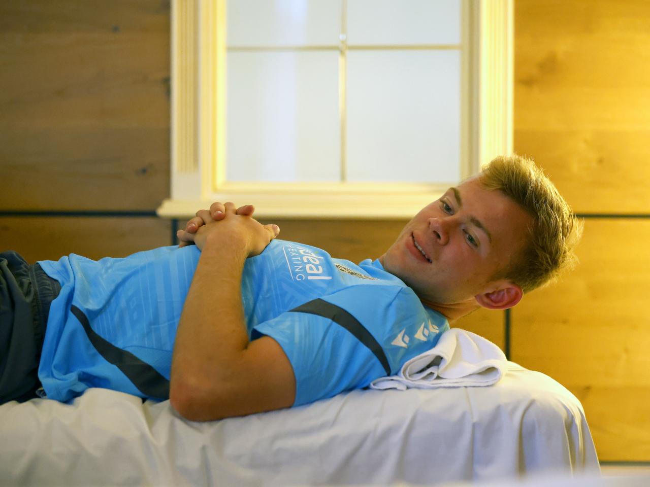 Aune Heggebø smiling while lying on a medical bed
