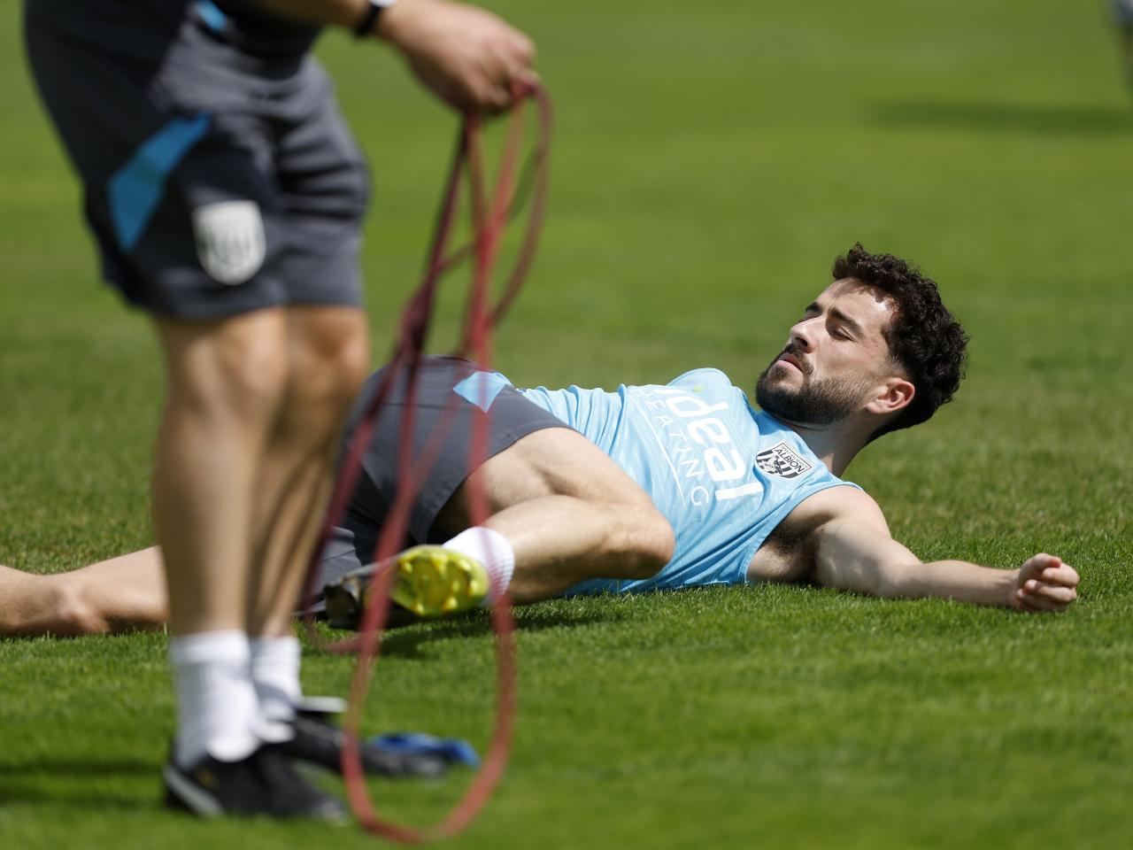 Mikey Johnston stretching during a training session in Austria
