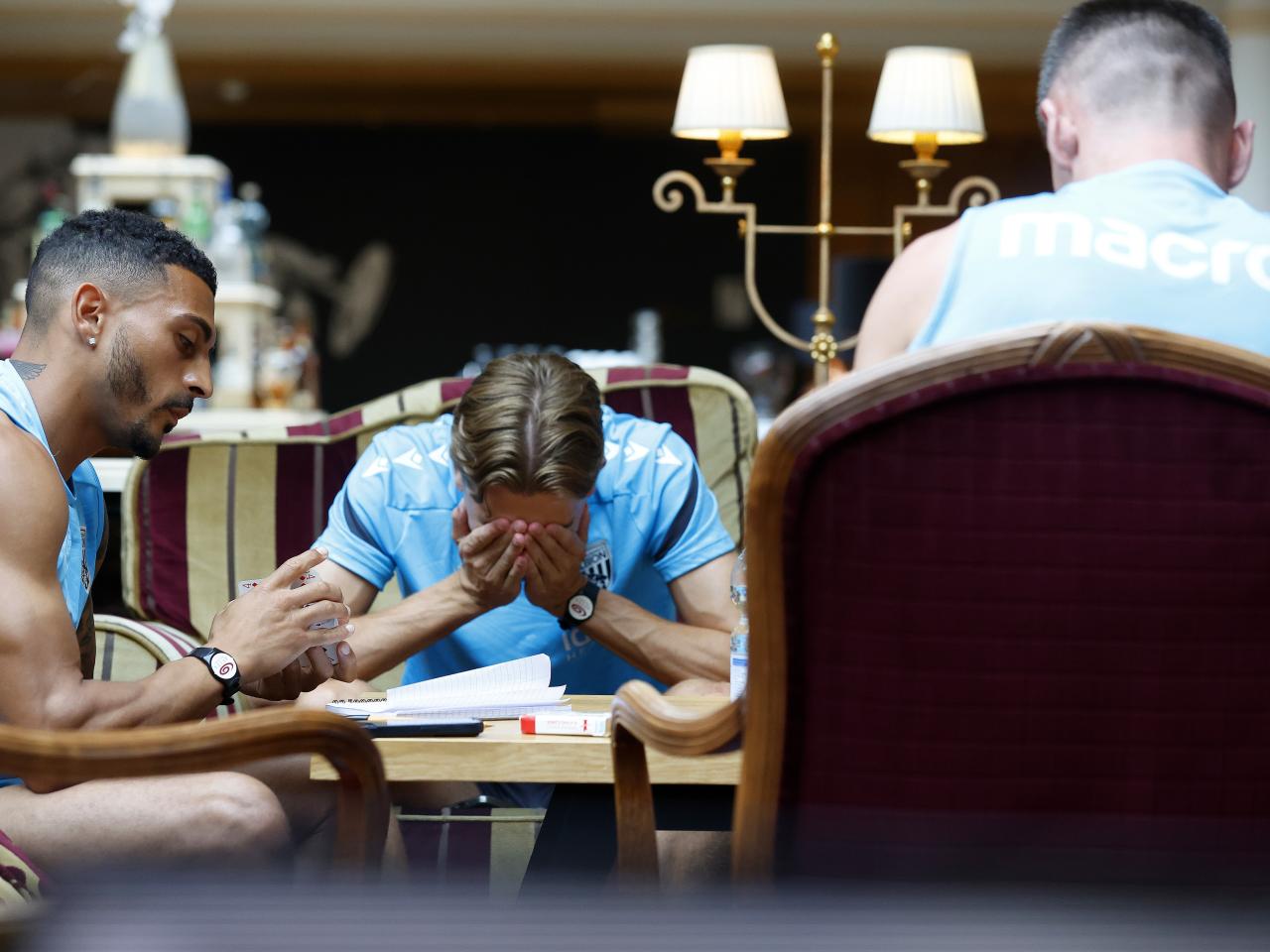Several Albion players playing cards with Isaac Price sat with his head in his hands