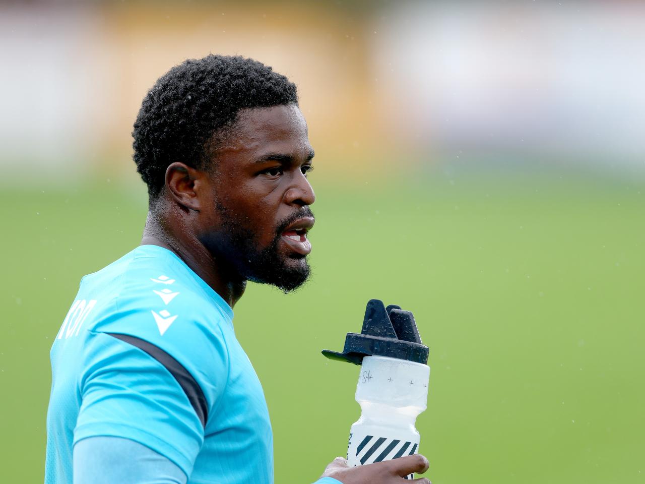 Josh Maja with a drink in his hand during a training session in the rain