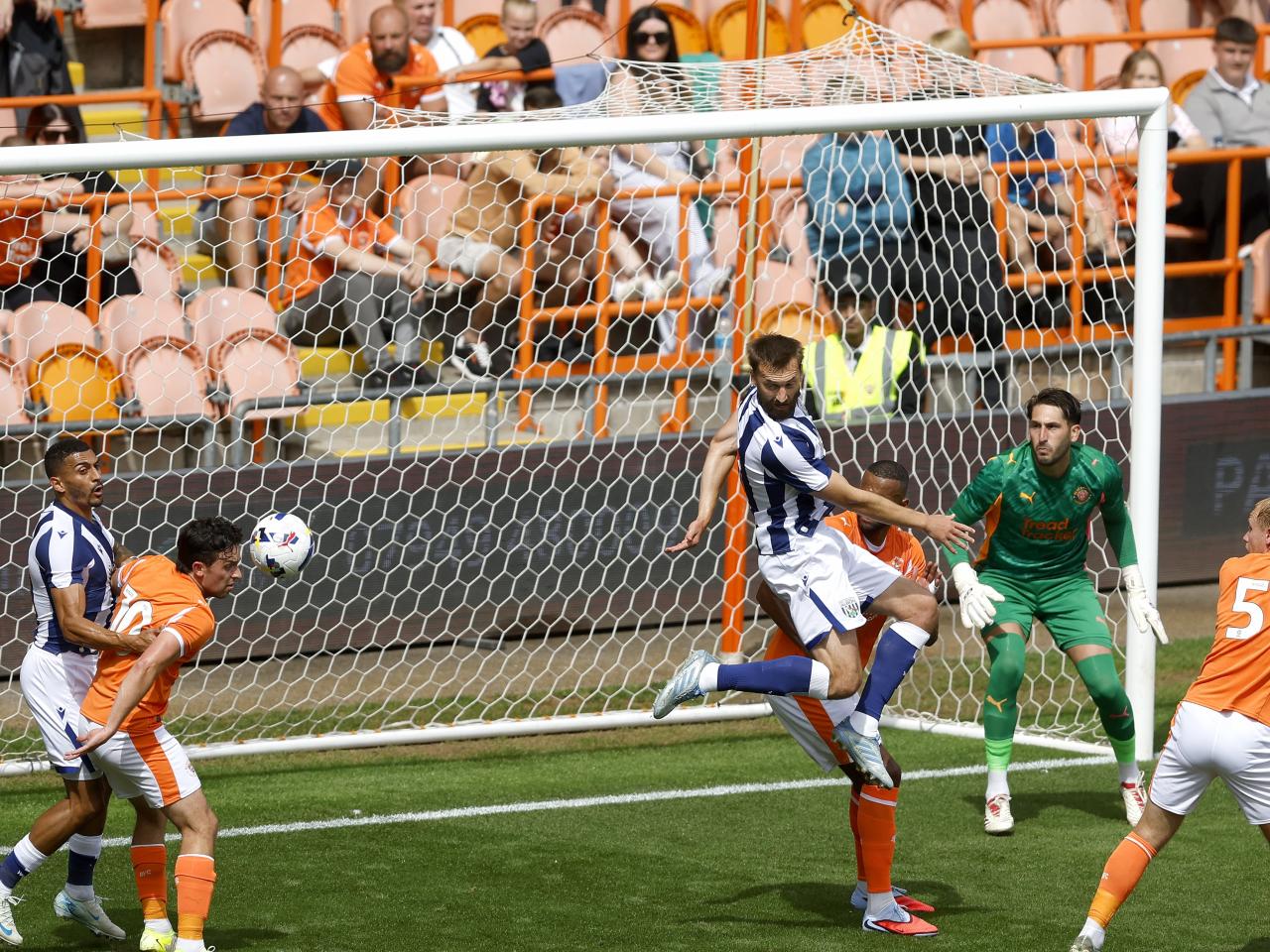 Nat Phillips trying to head the ball in the box surrounded by plenty of players from both teams 