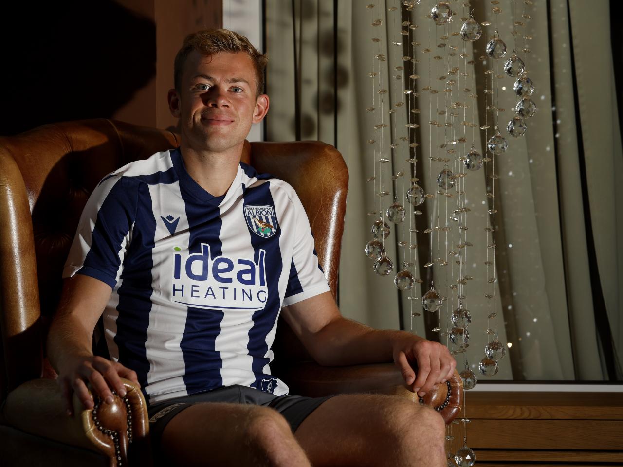 Aune Heggebø smiling at the camera while sat in a WBA shirt in a chair