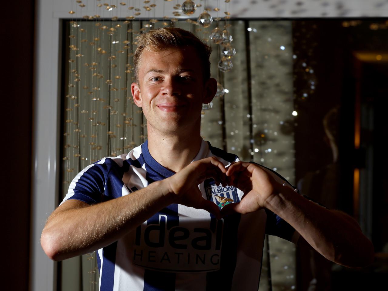 Aune Heggebø smiling at the camera while in a WBA shirt making a heart shape