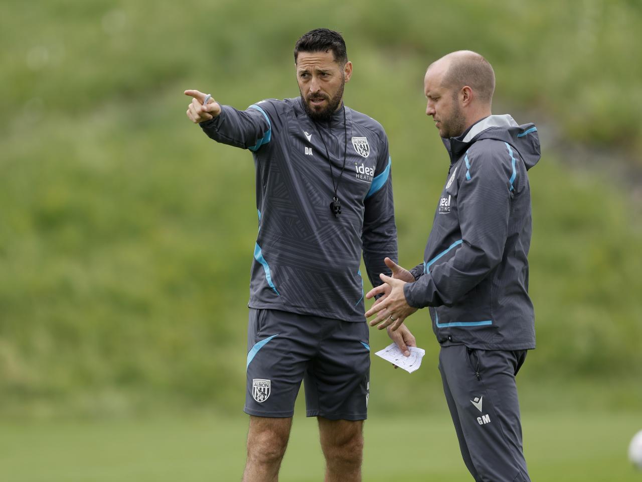 Damia Abella pointing forward while talking to a member of staff on the training pitch
