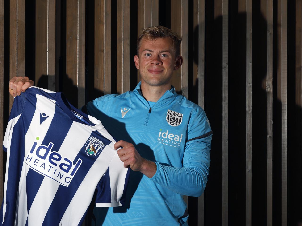 Aune Heggebø smiling at the camera and holding up a home shirt