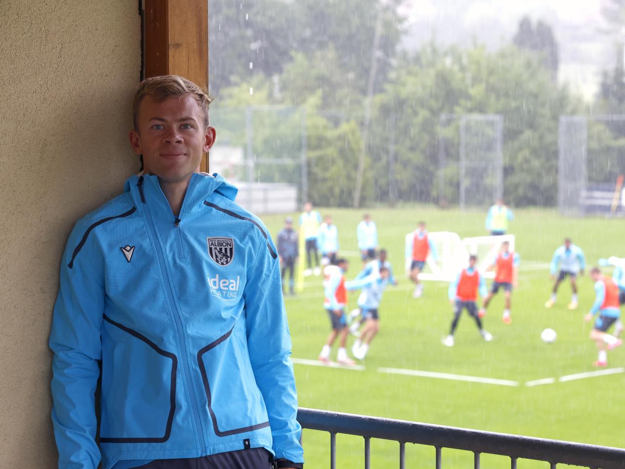 Aune Heggebø smiling at the camera while stood on a balcony watching training in Austria 