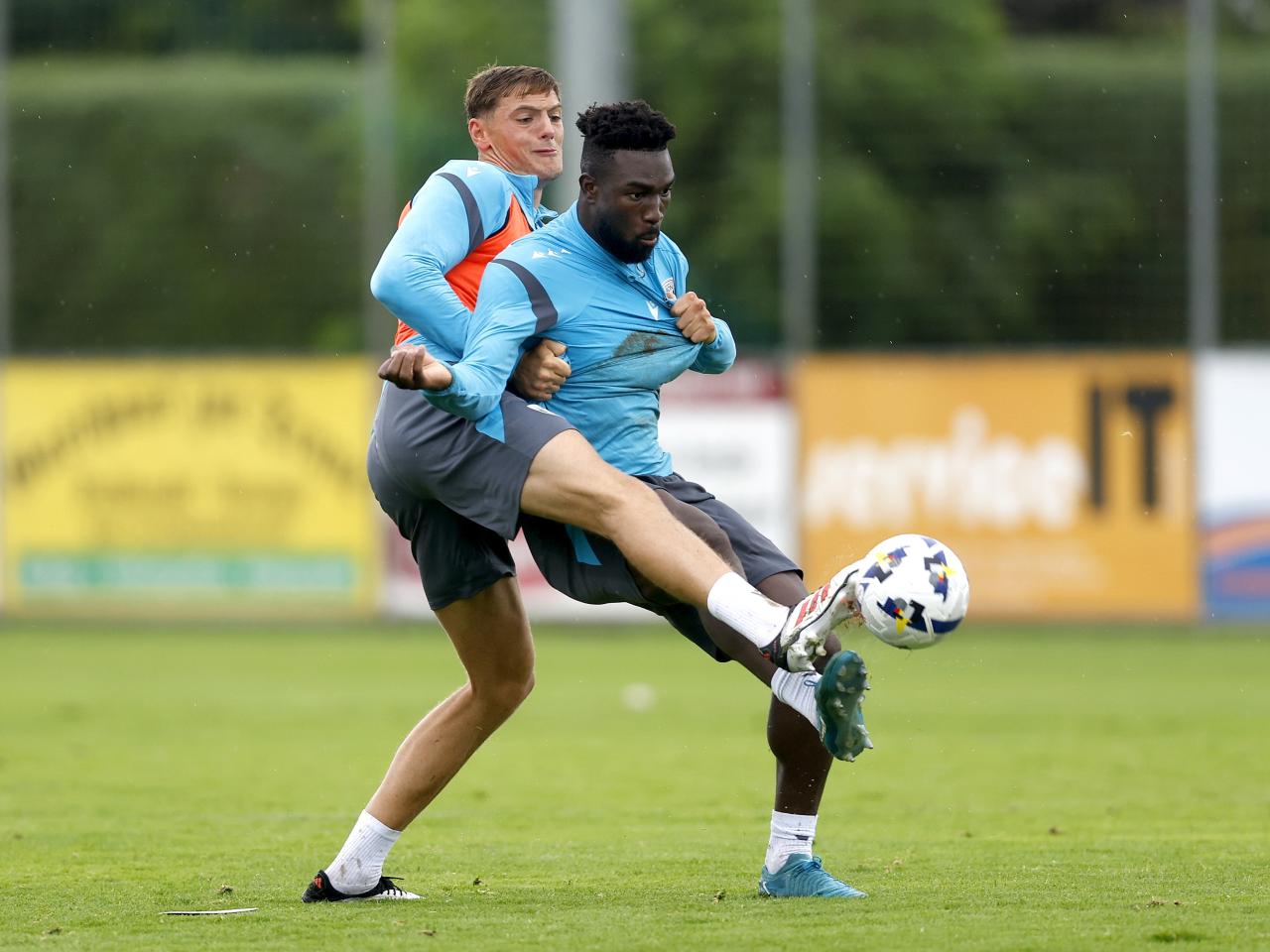Caleb Taylor and Daryl Dike fighting for the ball during a training session in the rain