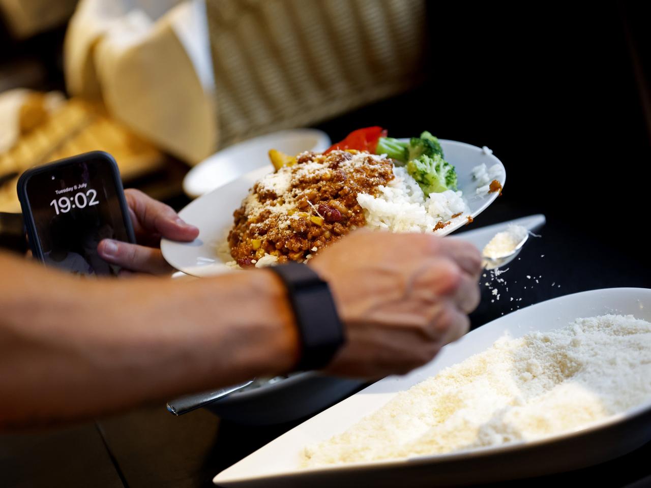 Dinner on a plate with mozzarella cheese being poured on