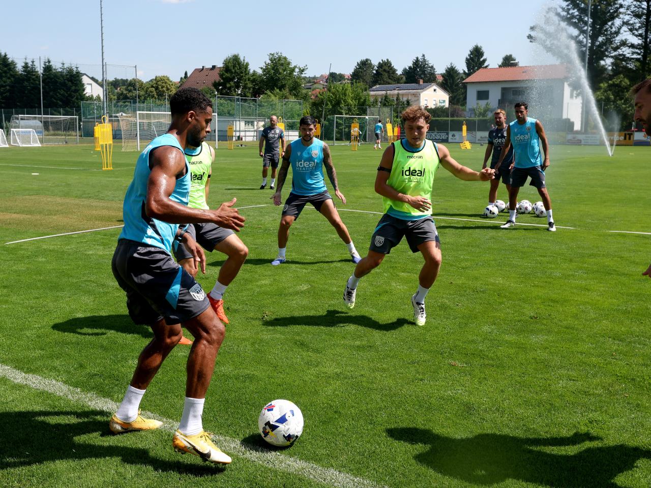 Darnell Furlong on the ball during a training session with several players around him