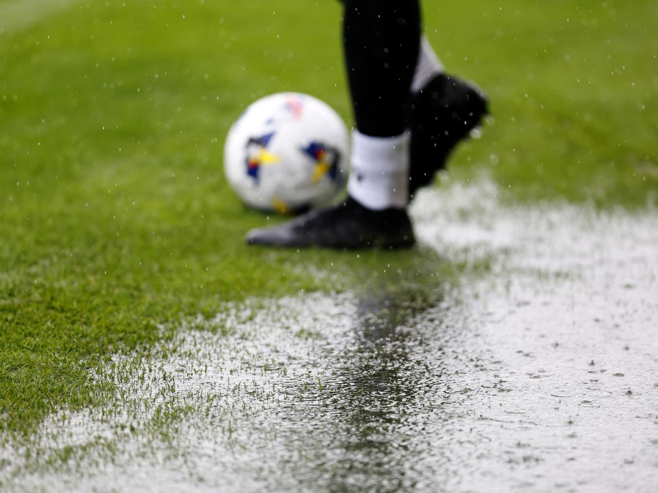 A general view of a rain puddle on the side of the pitch with a ball