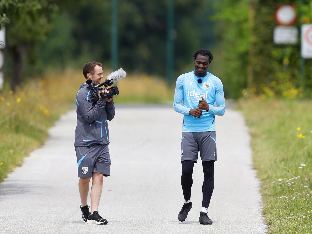 A WBA TV cameraman with Ousmane Diakité on a path in Austria 
