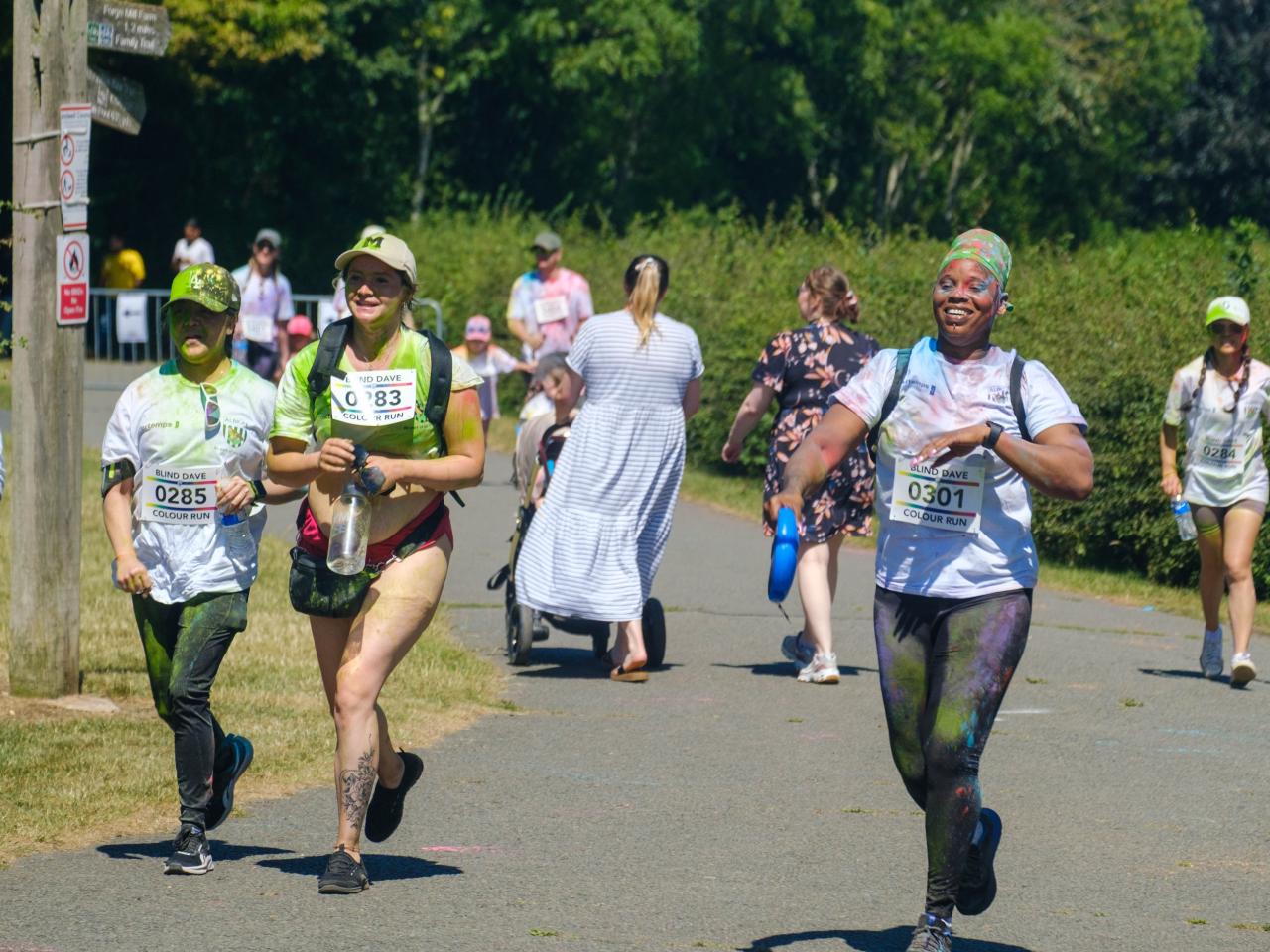 More runners smiling, heading towards the finish line.