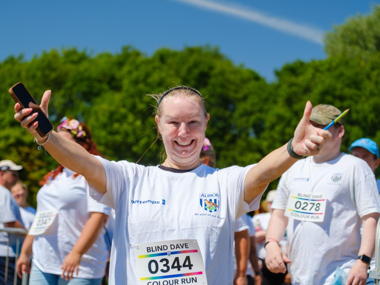 A runners walking in to the warm up area, with arms out in joy.