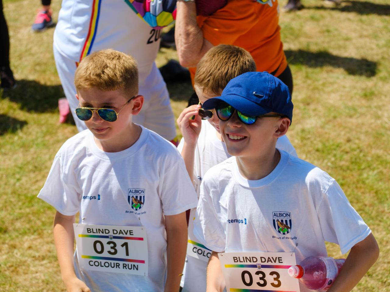Young participants smiling, wearing sunglasses.