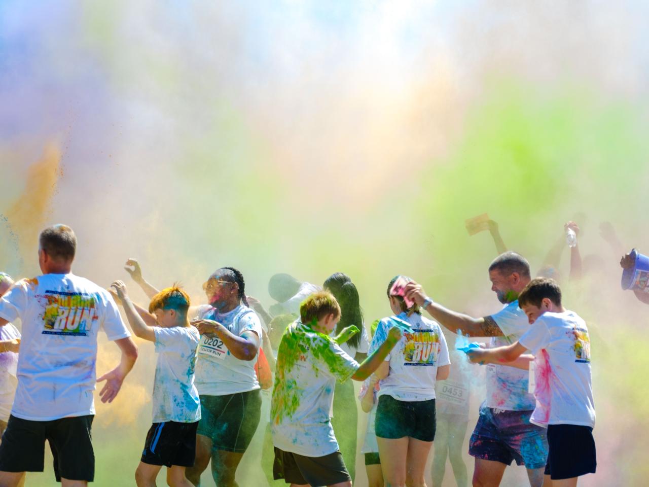 Cloud of colour after the paint throw, participants cover in paint.