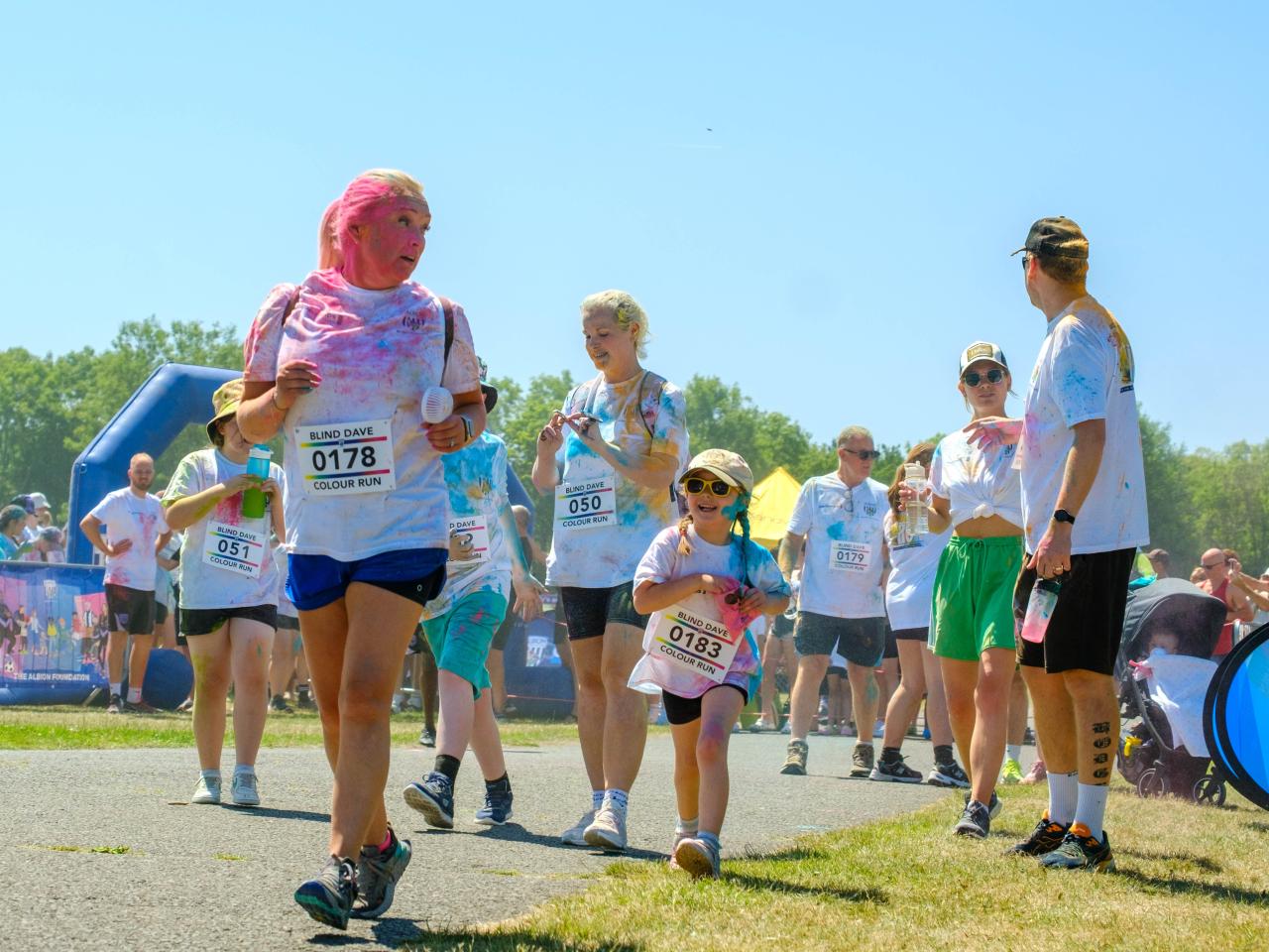 Runners covered in paint, leaving the start line.