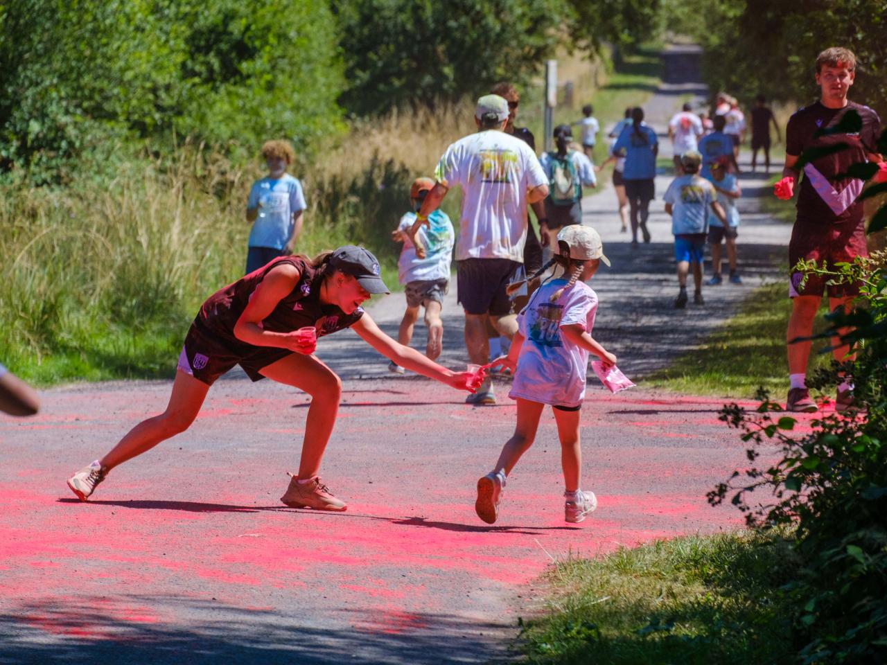 Foundation staff aiming paint powder at a passing runner.