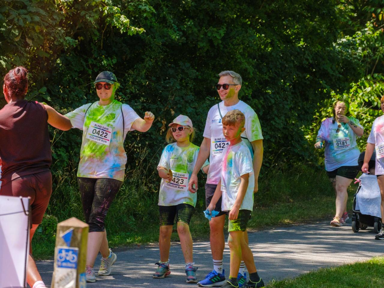 Family of runners waiting in anticipating to be doused with red powder.