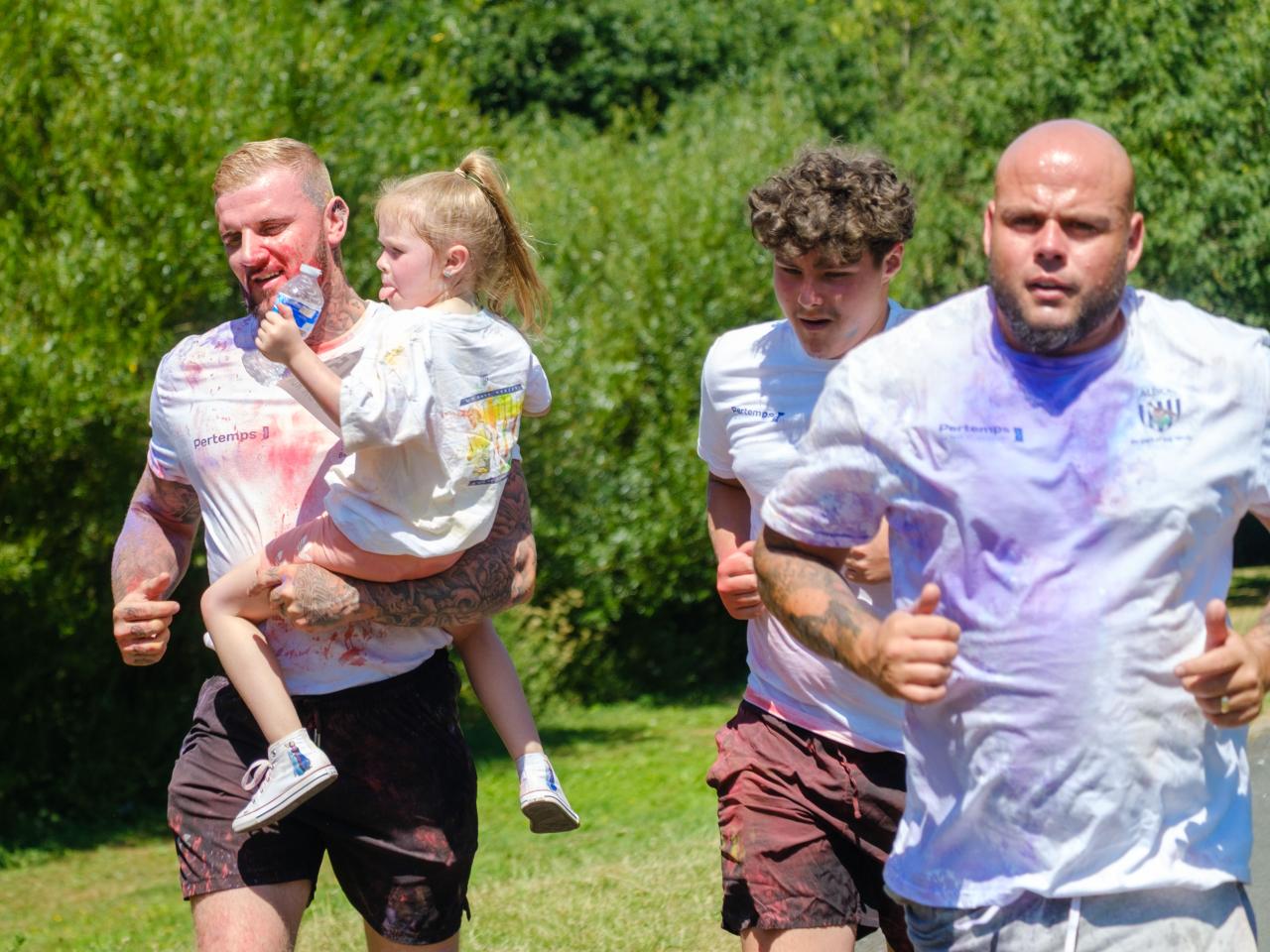 Three adult men, with one carrying a child.