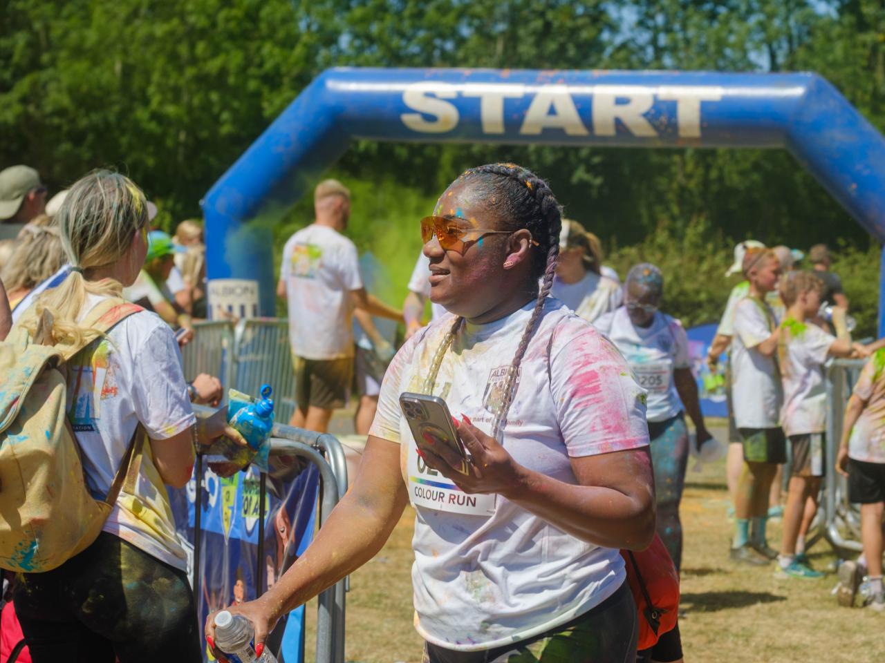 Woman holding her phone and water bottle.