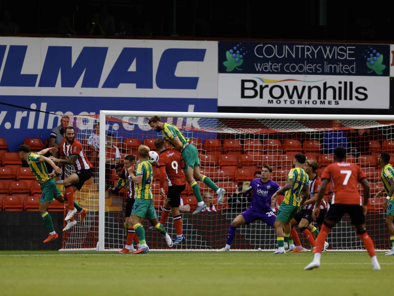 A photo of Nat Phillips in the 2025/26 green and yellow away kit