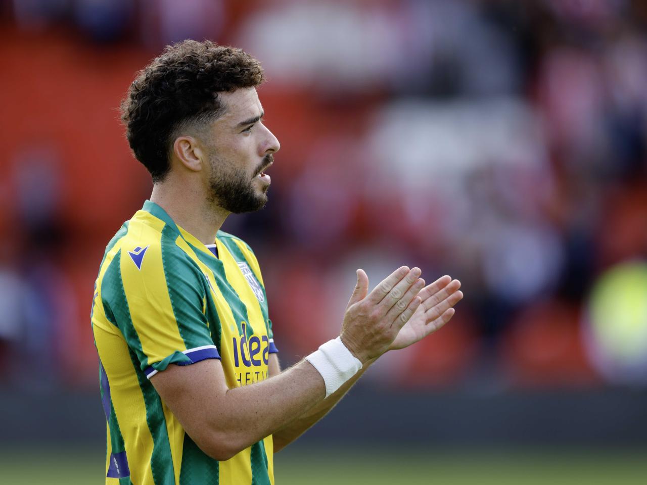 A photo of Mikey Johnston applauding the Albion fans at Lincoln