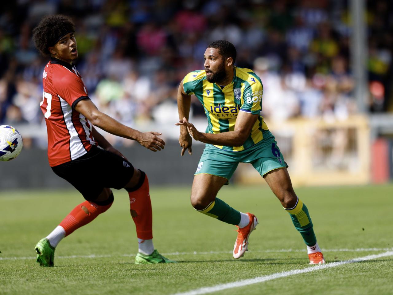 A photo of George Campbell in the 2025/26 green and yellow away kit