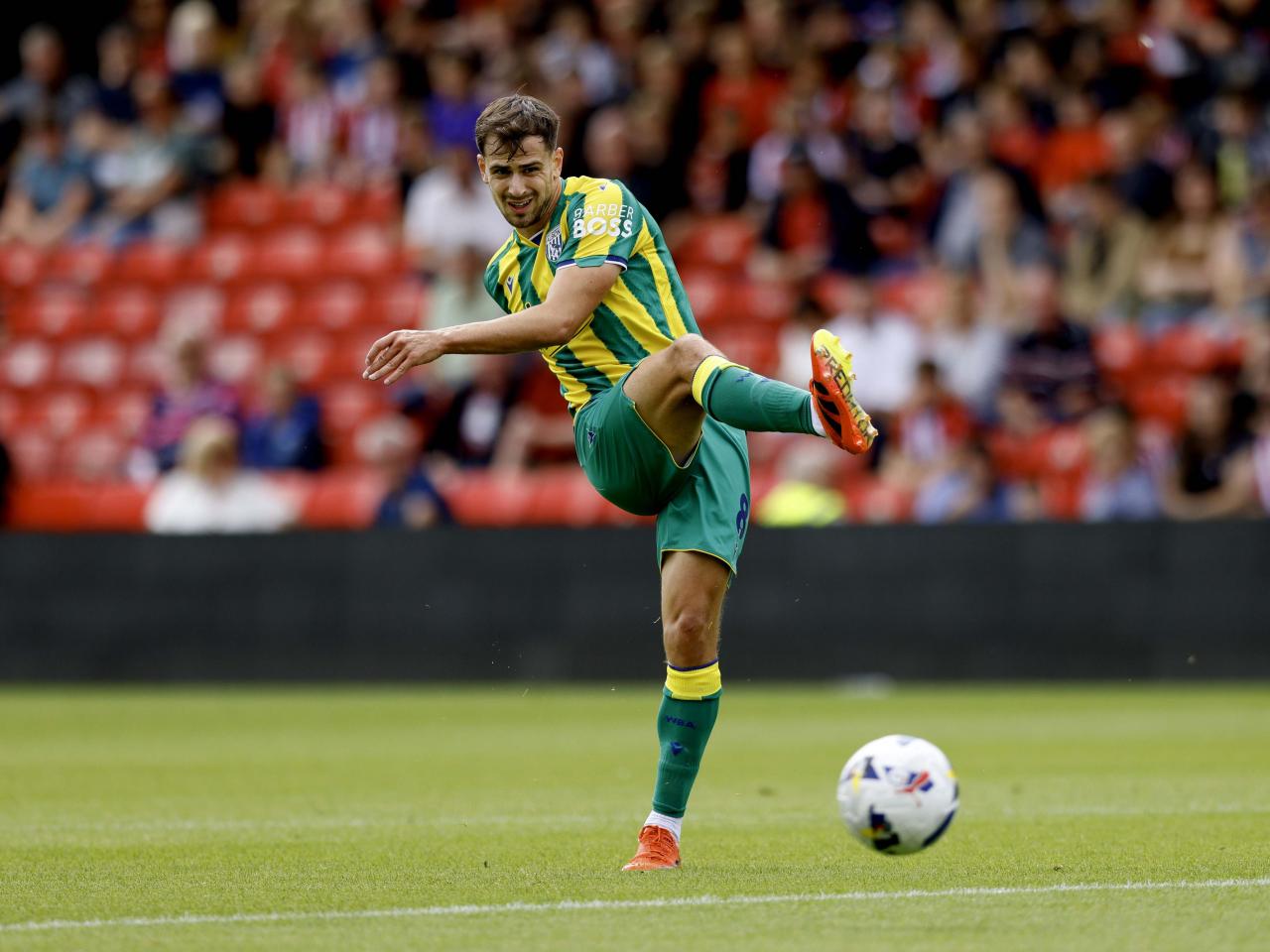 A photo of Jayson Molumby in the 2025/26 green and yellow away kit