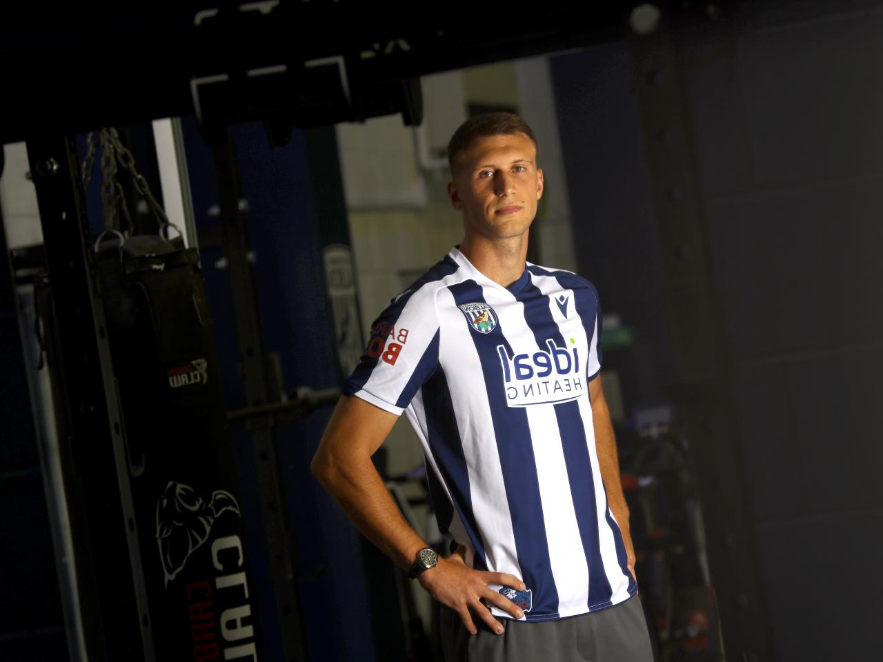 Krystian Bielik in a home shirt in the gym looking at the camera 