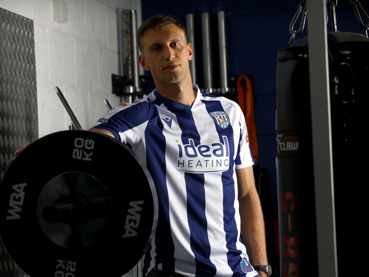 Krystian Bielik in a home shirt in the gym looking at the camera 