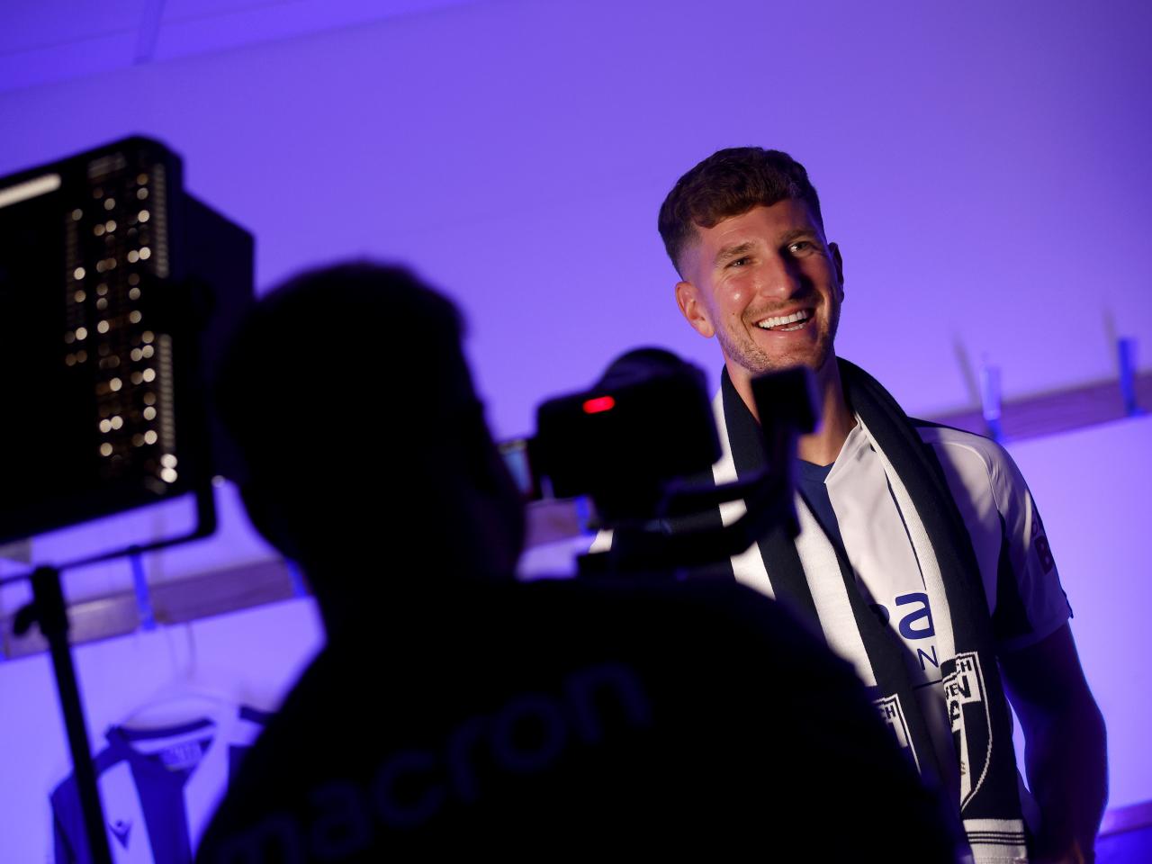 Chris Mepham smiling while being filmed by WBA TV
