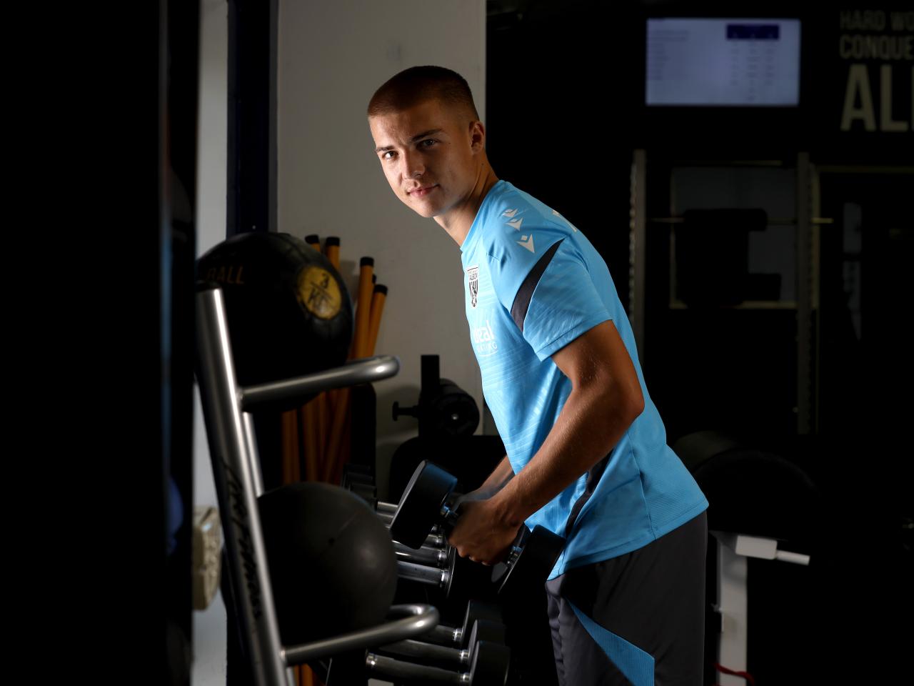 Alfie Gilchrist leaning forward in the gym looking at the camera 