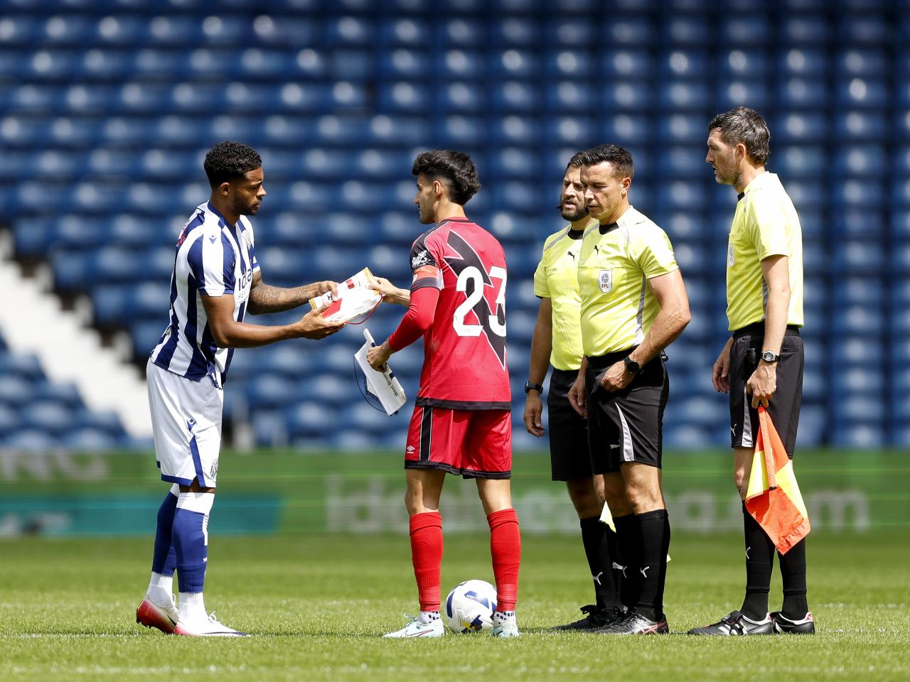 Darnell Furlong and Rayo Vallecano's captain shake hands and swap gifts before kick-off in the centre circle