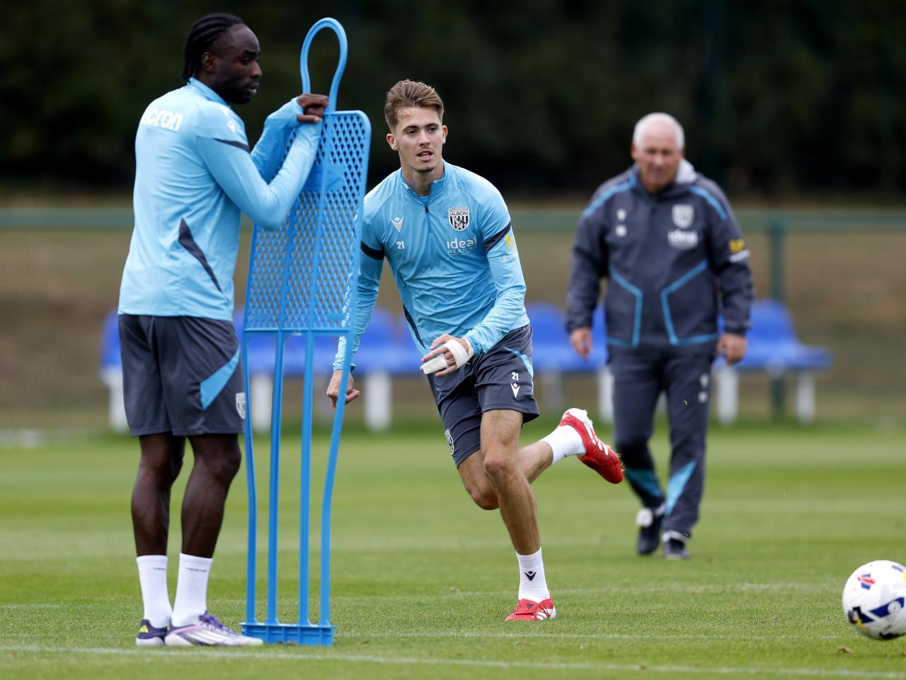 Isaac Price running past a mannequin during training 