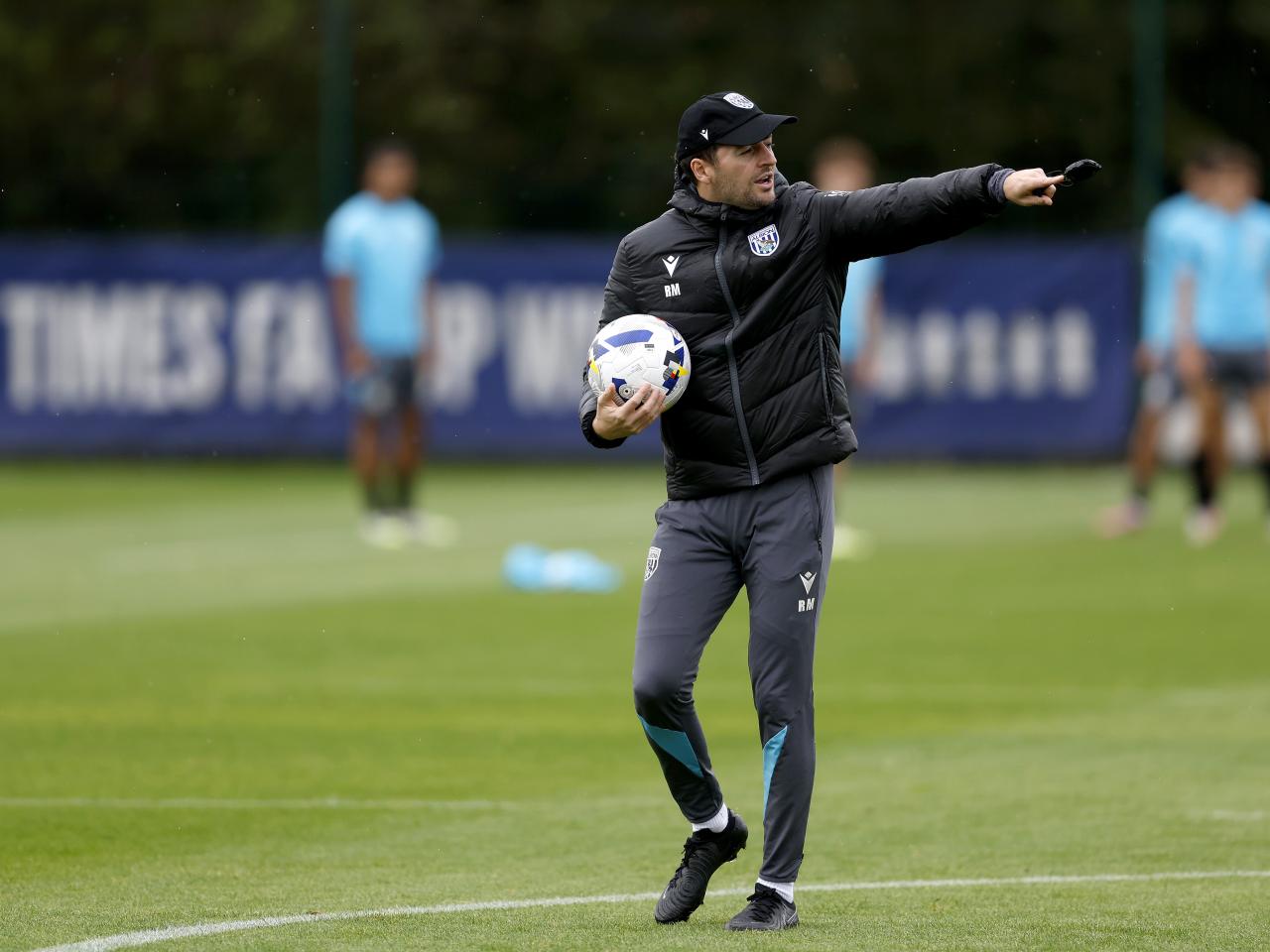 Ryan Mason with a cap on and a stopwatch in training