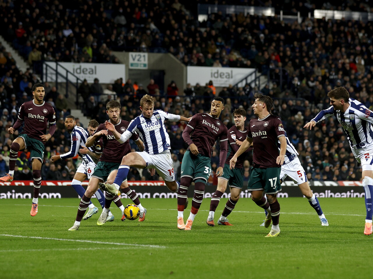 Several players battling to win the ball in the penalty area during the game between WBA and Swansea